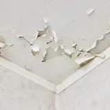 Łuszcząca się farba na suficie to problem, jak ukryć nierówny sufit. Warto rozważyć montaż podwieszanego sufitu lub zastosowanie płyt gipsowo-kartonowych.