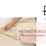 Dłoń z miarką mierzy dywan przy listwie przypodłogowej. Dowiedz się, jak obliczyć metraż pokoju.