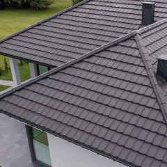 Szary dach z dachówki ceramicznej, z dwoma kominami. Zastanawiasz się, ile waży dachówka ceramiczna?