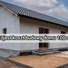 Dom w trakcie budowy, szary tynk, ciemny dach. Pytanie na zdjęciu: Jaki jest koszt budowy domu 100 m²?
