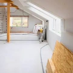 Budowa domu 30m2 w toku: rusztowania, materiały budowlane, instalacje.