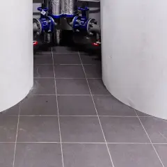 Kotłownia w płytkach. Dwa białe cylindry otaczają instalację hydrauliczną z niebieskimi zaworami.