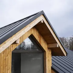 Drewniana ściana szczytowa i czarny dach z blachy. Rozważasz, jak ocieplić stary dach z blachy?