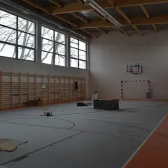 Wnętrze hali sportowej w budowie, z drabinkami, koszem i bramką. Zastanawiasz się, ile kosztuje budowa hali sportowej?