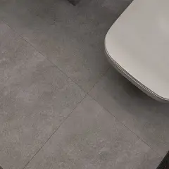 Nowoczesne wzory układania płytek 60x60 w łazience. Szare, wielkoformatowe płytki tworzą minimalistyczną bazę dla białej wanny.