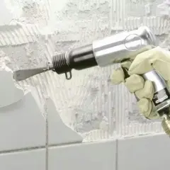 Rękawica z narzędziem pneumatycznym usuwa stare płytki i zaprawę. Skuteczny sposób, jak usunąć kit i przygotować ścianę do remontu.