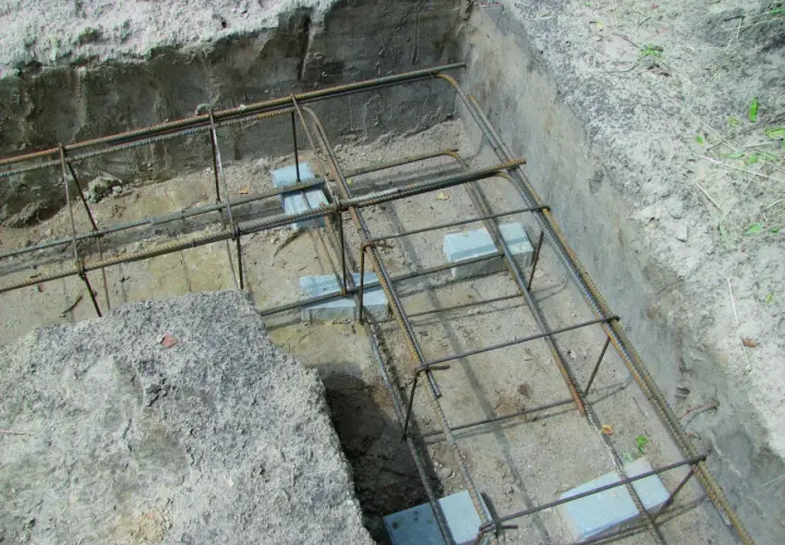 Zbrojenie fundamentów w narożnikach, gotowe do zalania betonem. Widać staranne łączenie zbrojenia w narożnikach.