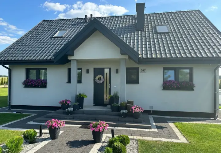 Nowoczesny dom Kamilek 100m2 z pięknymi kwiatami w donicach i skrzynkach.