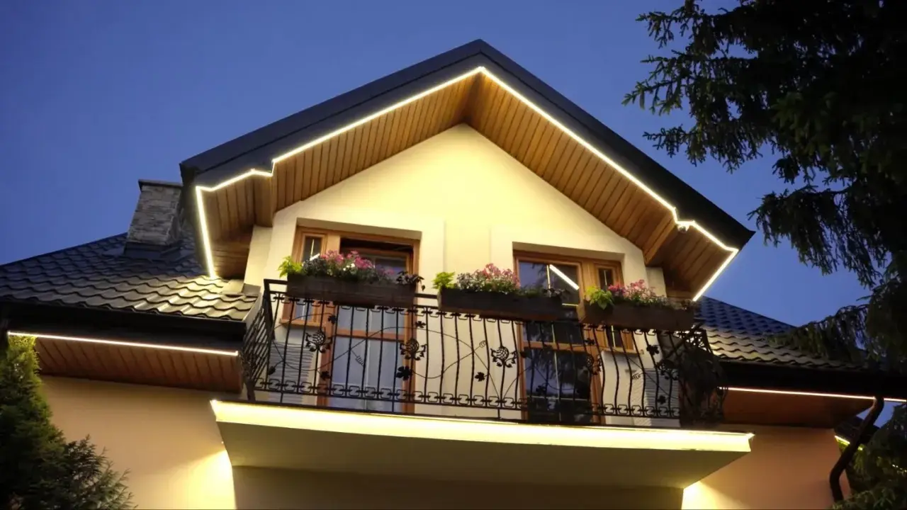 Eleganckie halogeny w podbitce podkreślają architekturę domu, tworząc ciepłą atmosferę wieczorem.