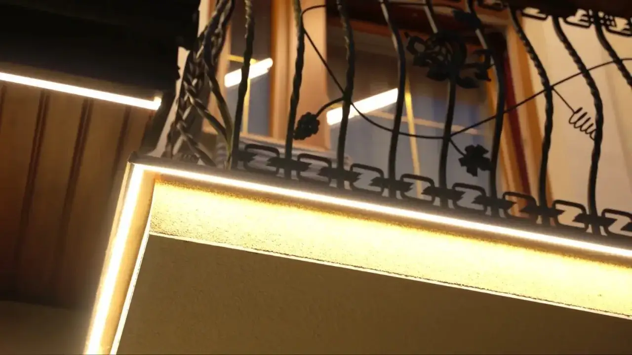 Eleganckie halogeny w podbitce podkreślają urokliwy, ozdobny balkon.