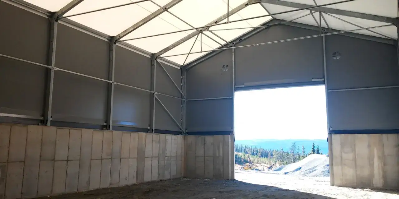 Wnętrze hali z betonową podmurówką i szarymi ścianami. Zastanawiasz się, ile kosztuje pozwolenie na budowę hali?