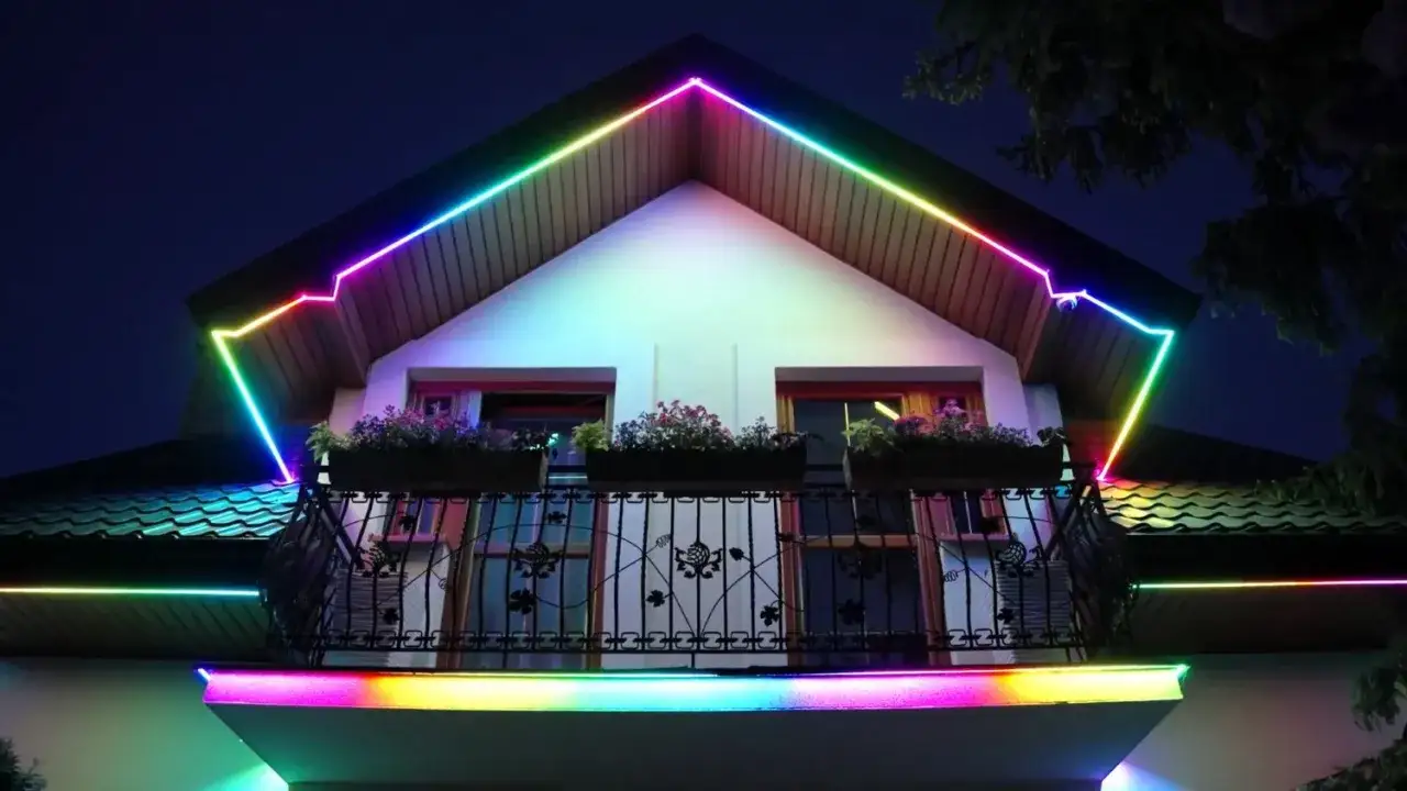 Kolorowe taśmy LED, przypominające halogeny w podbitce, oświetlają dach i balkon domu, tworząc magiczną atmosferę.