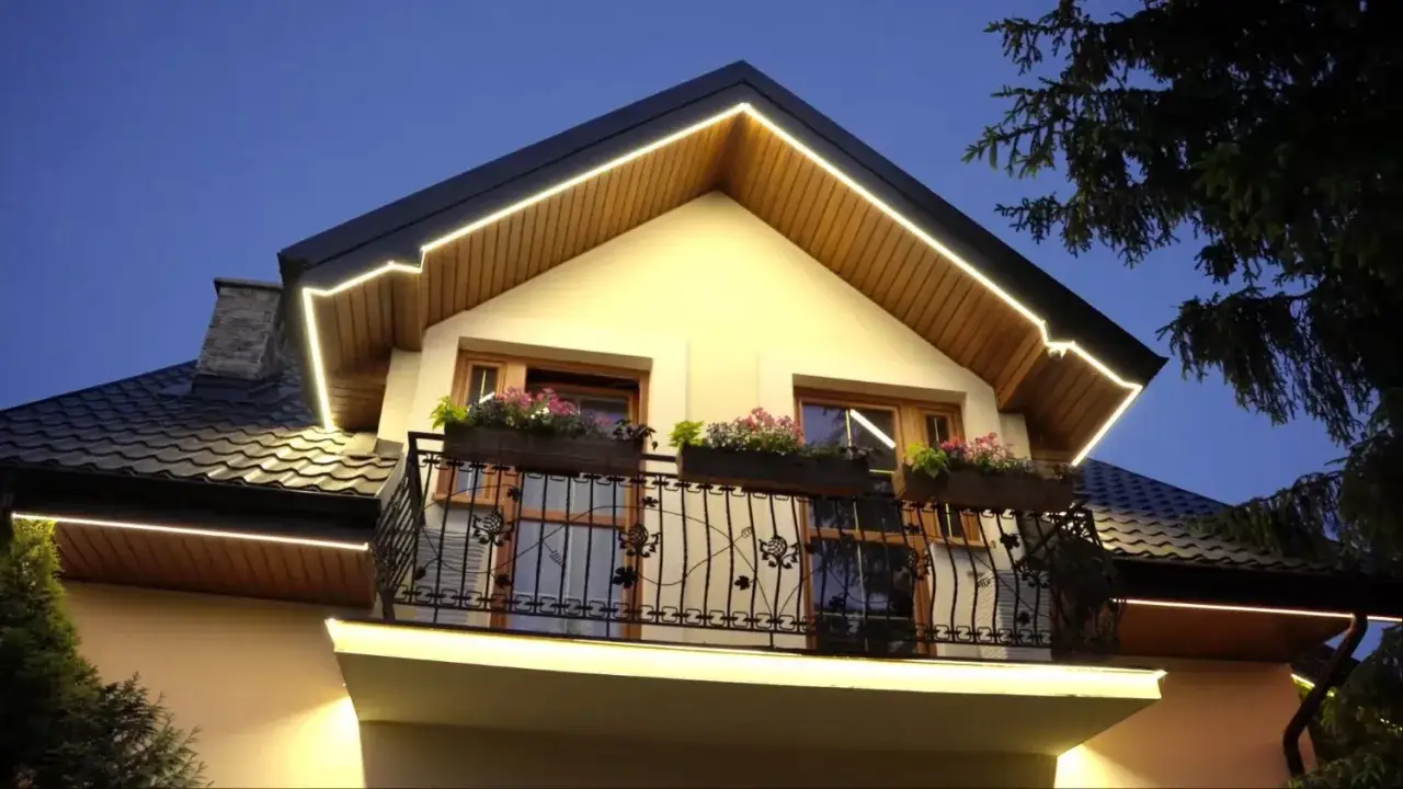 Eleganckie halogeny w podbitce podkreślają architekturę domu, tworząc przytulną atmosferę wieczorem.